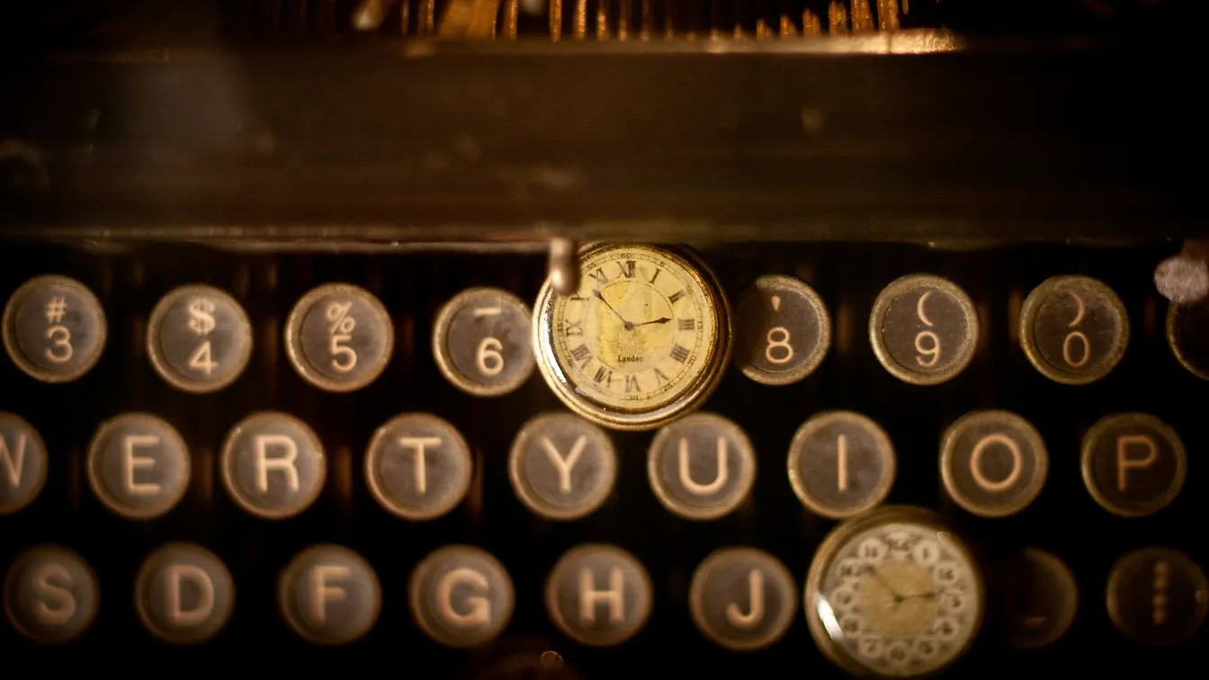 a close up of an old typewriter with a clock