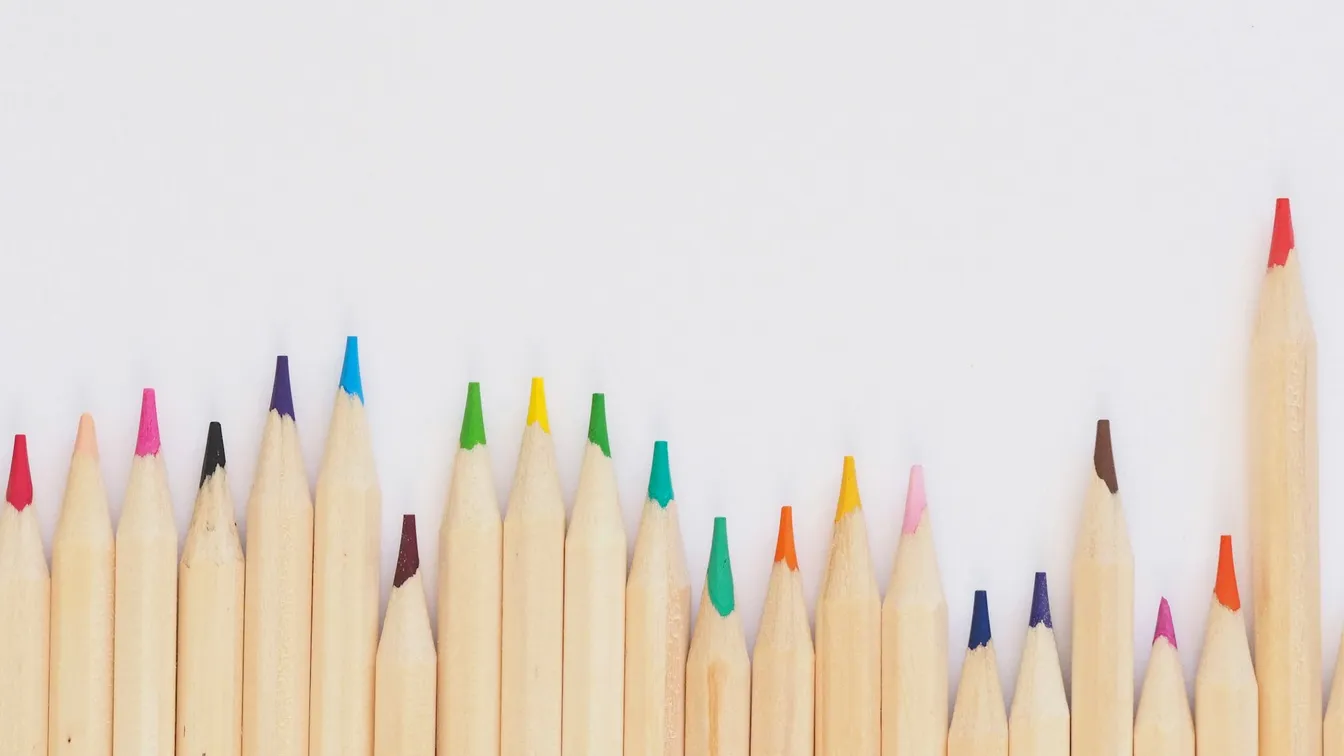 a row of colored pencils on a white background