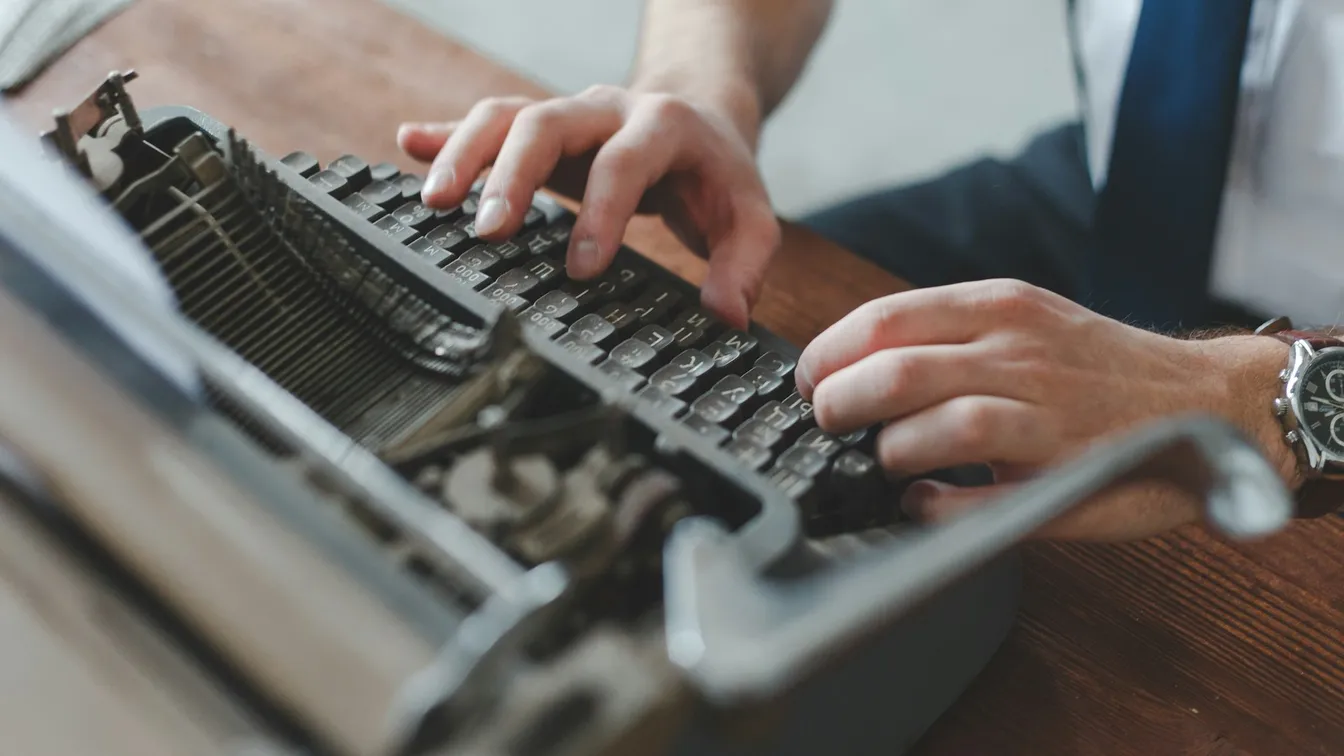 a man in a suit typing on a typewriter