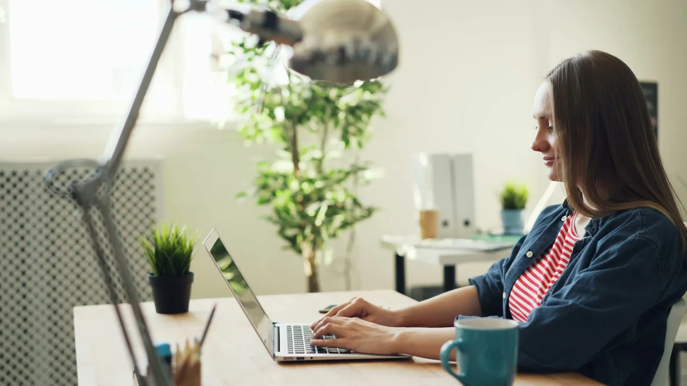 a woman working on a laptop in her home office