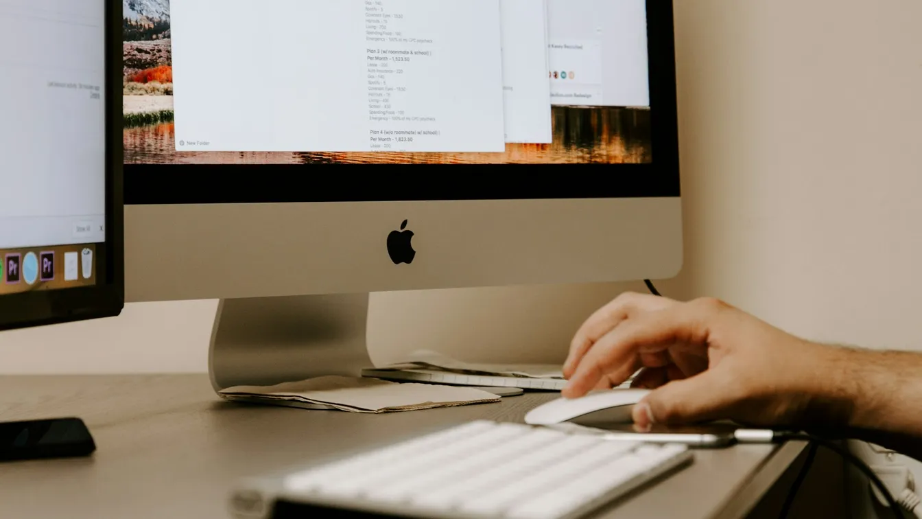 a man typing on a computer screen in front of a monitor