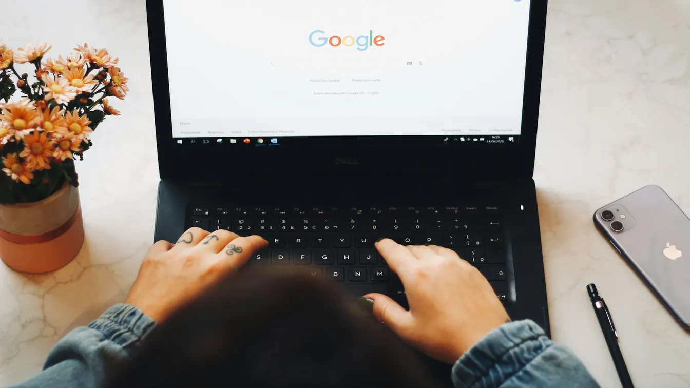 a woman typing on a laptop with the google logo on it