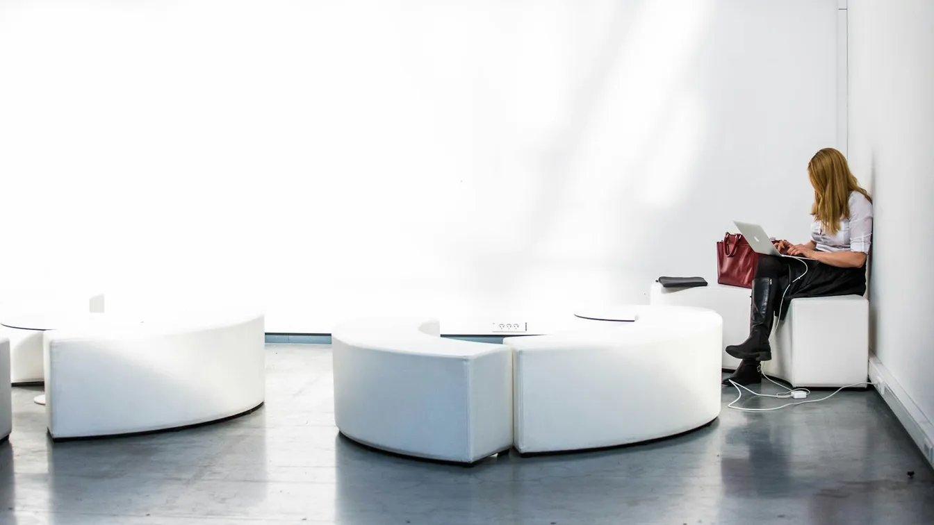 a woman is sitting on a white chair in a room