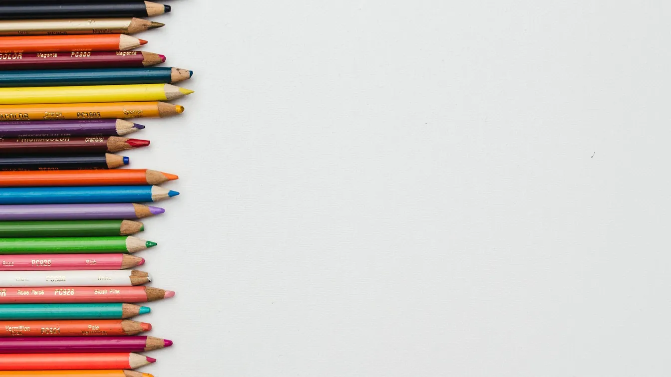 a row of colored pencils on a white background