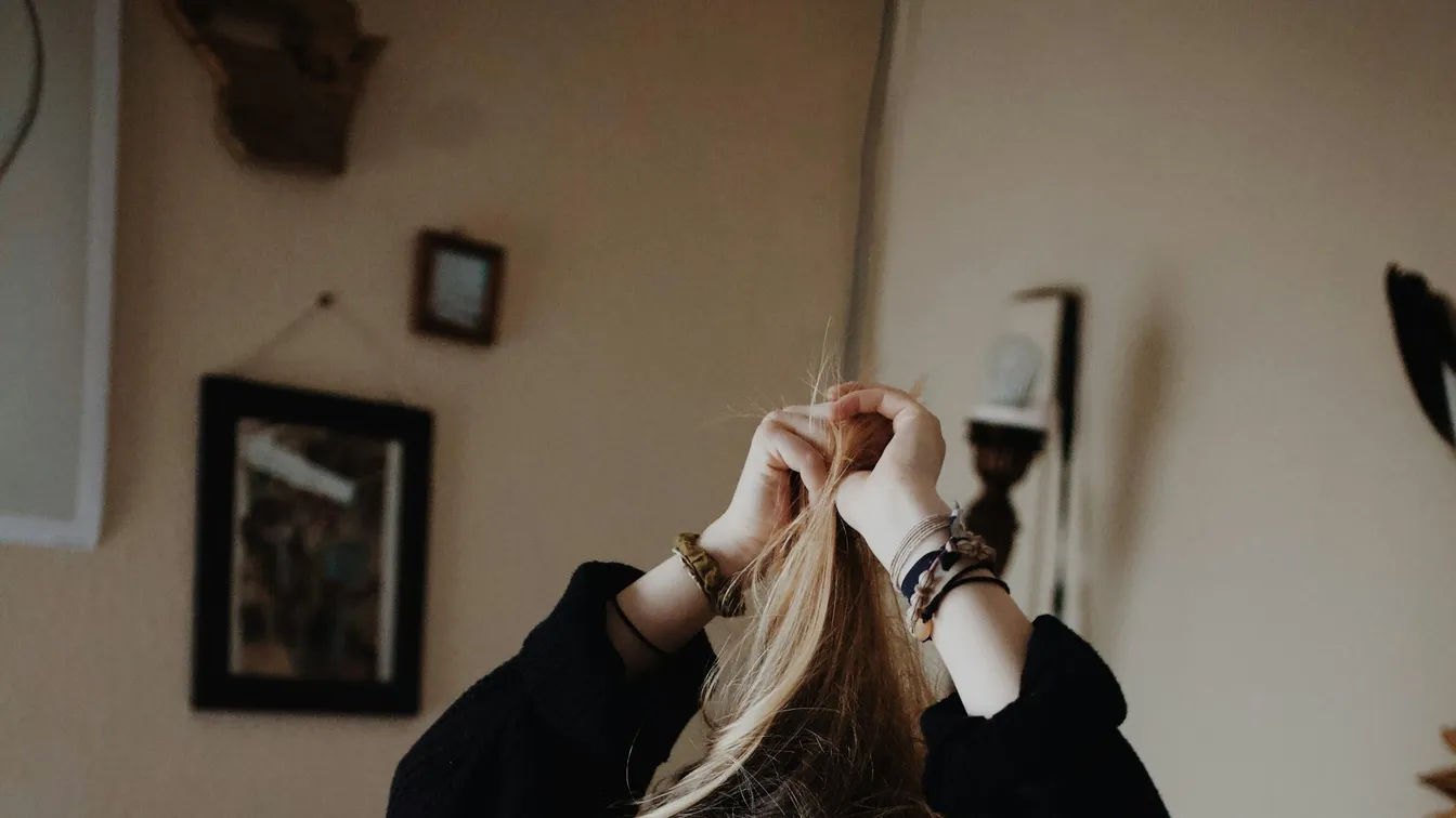 a woman combing her hair in front of a mirror