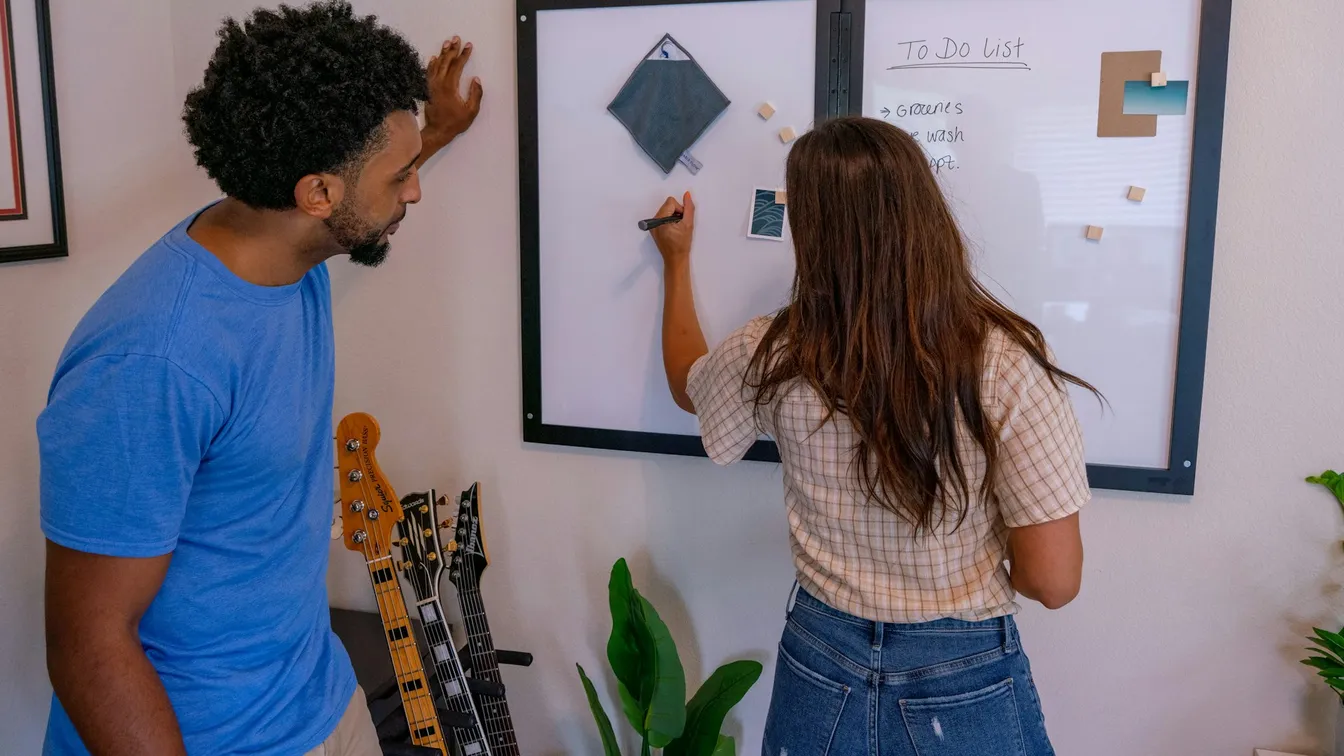 a man and woman standing in front of a whiteboard